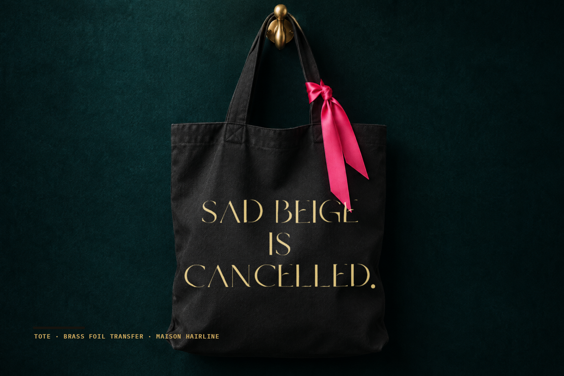 Maison Hairline on a black tote bag with SAD BEIGE IS CANCELLED in brass foil and a pink ribbon
